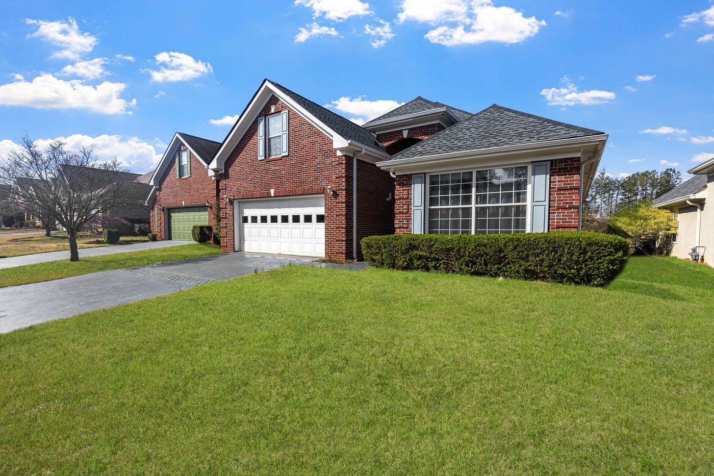 A red brick house with a well kept lawn on a quiet residential street