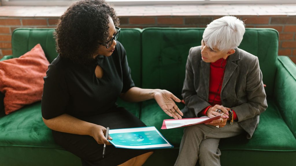 Two people going through paperwork together on a sofa